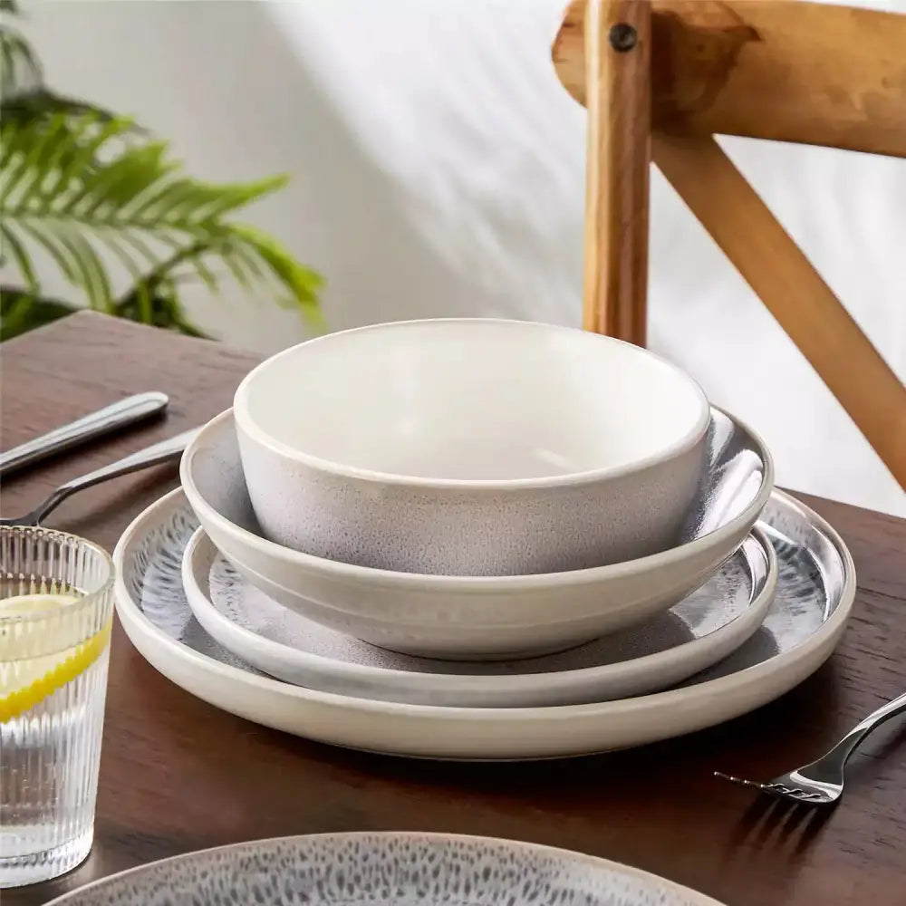 Stack av tre keramikkplatser och en skål med texturerad, prickig finish PIERRE Servis