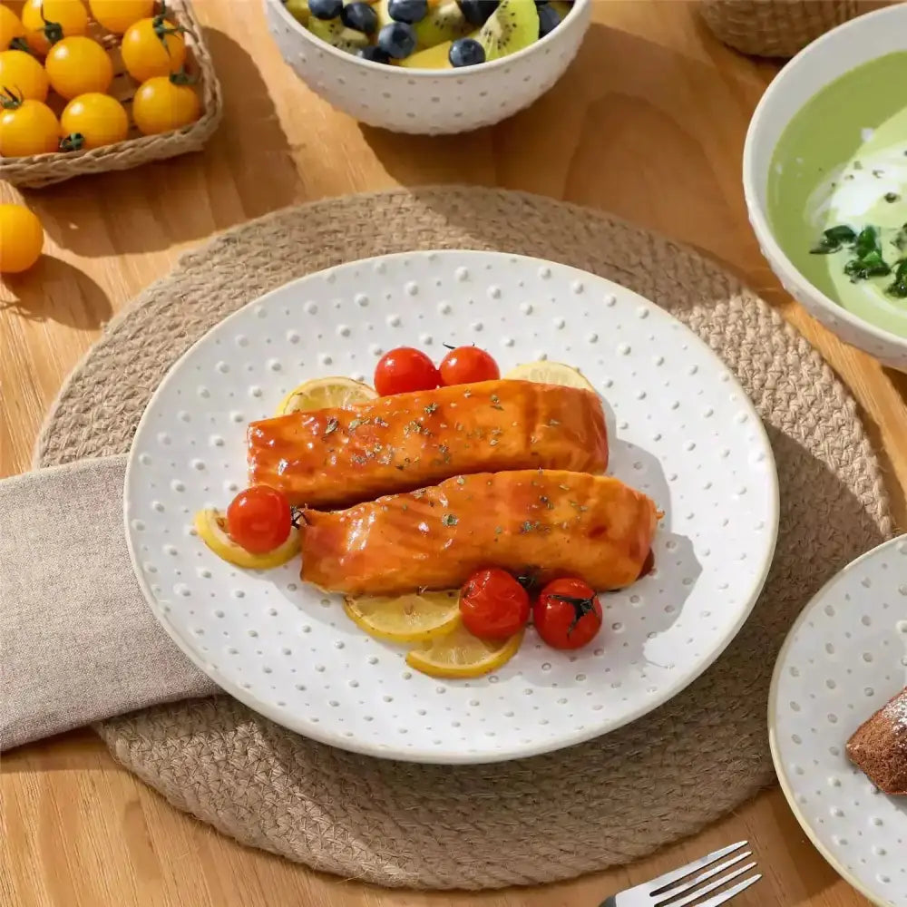 Glaserade laxfiléer med citron och tomater på vit dimpled plate QVIST Servis 16 delar